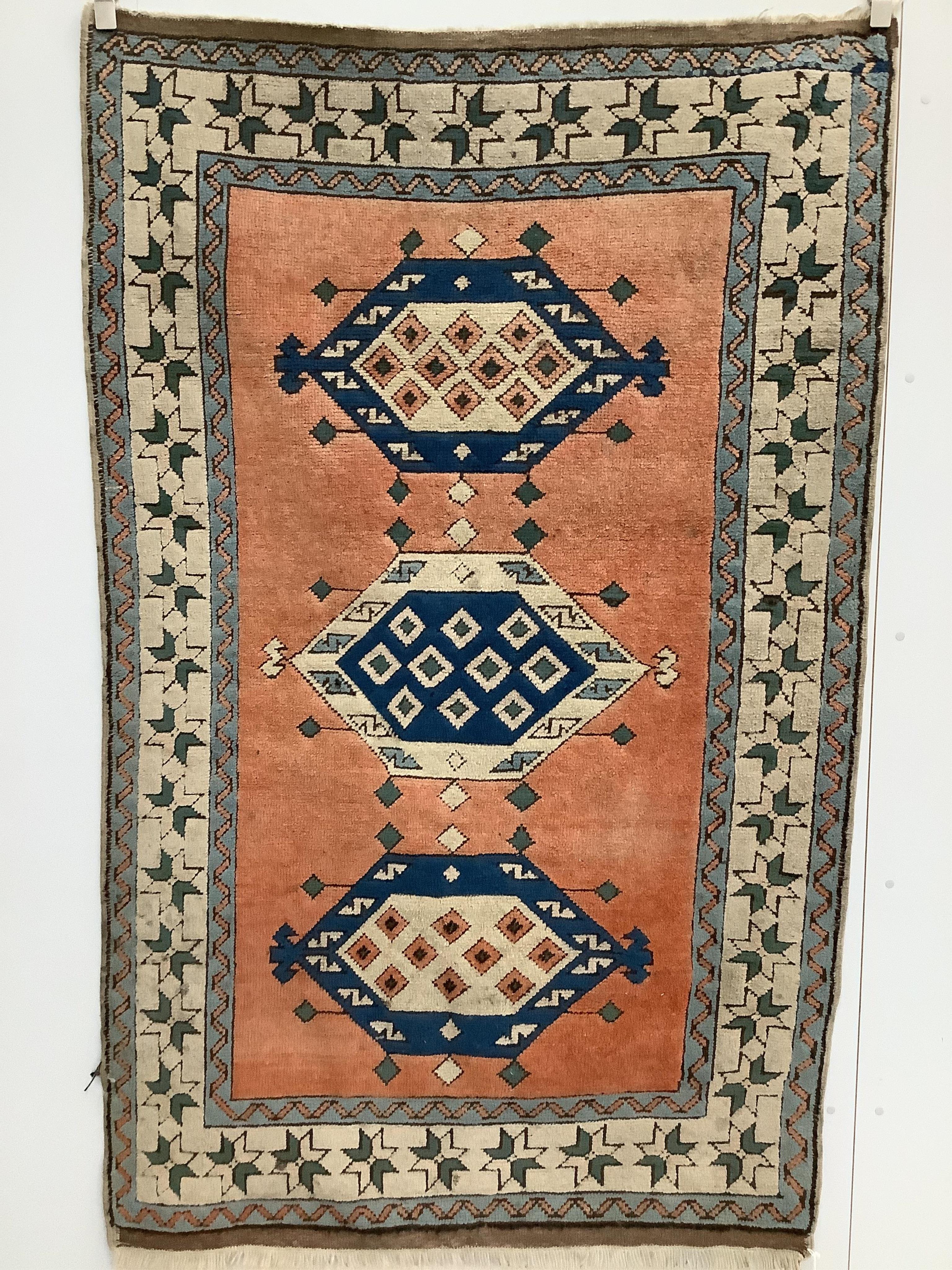 A Caucasian style brick red ground rug, 210 x 130cm